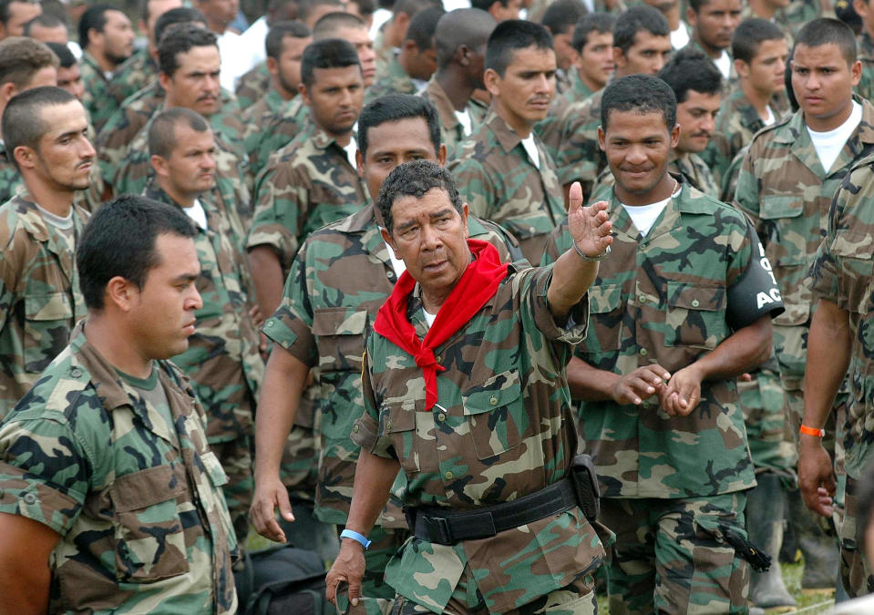 FILE - In this Feb. 7, 2006 file photo, Ramon Isaza, center, commander of the Magdalena Medio Bloc, speaks with his men before turning in their weapons during a disarmament ceremony in Puerto Triunfo, Colombia. Hundreds of right-wing paramilitaries are expected to walk free from prison starting in March 2014 after serving eight-year sentences for crimes that normally carry more than triple the prison terms. Isaza, who is due to be released in October 2014, created the first of the right-wing militias at the end of the 1970s in the Magdalena Valley. (AP Photo/Luis Benavides, File)