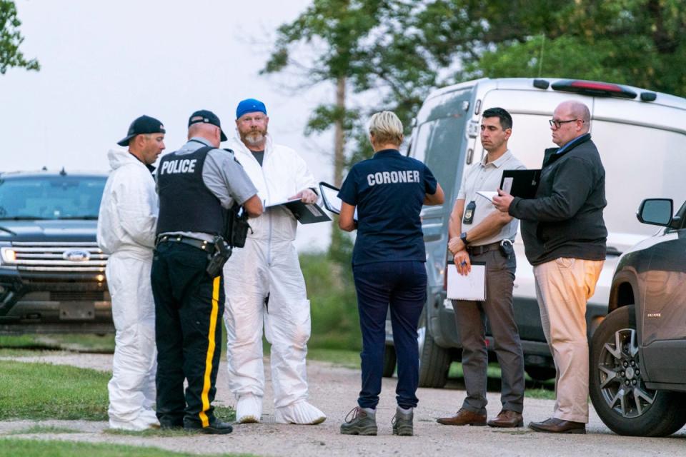 Investigators gather in front of the scene of a stabbing in Weldon, Saskatchewan (AP)