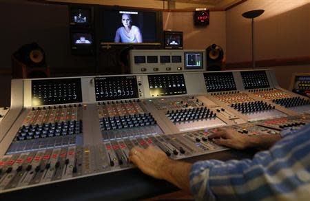 Opera Singer Angela Denoke playing the role of Kundry appears on a screen in the sound room during a live broadcast of the opera "Parsifal" from the Royal Opera House in London December 18, 2013. REUTERS/Suzanne Plunkett