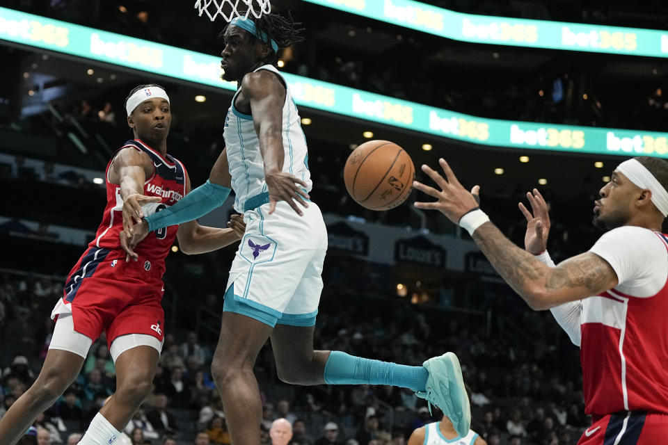 Washington Wizards guard Bilal Coulibaly passes around Charlotte Hornets center Mark Williams to center Daniel Gafford during the first half of an NBA basketball game on Wednesday, Nov. 22, 2023, in Charlotte, N.C. (AP Photo/Chris Carlson)