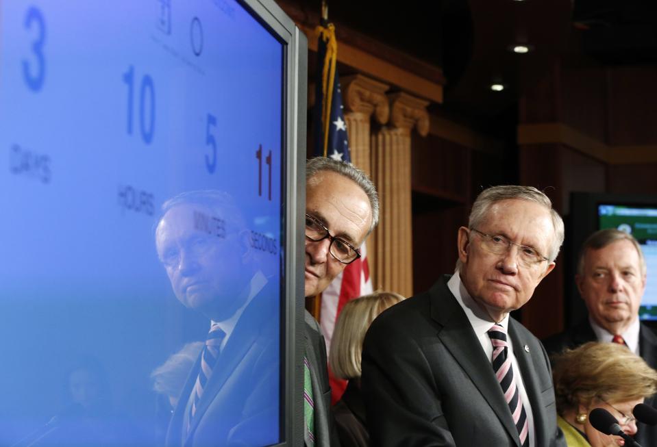 U.S. Senate Majority Leader Harry Reid (D-NV) (3rd R) looks at a screen showing a clock counting down to a government shutdown, at a news conference with fellow Democrats Senator Chuck Schumer (D-NY) (4th R), Senator Barbara Mikulski (D-MD) (2nd R) and Senator Dick Durbin (D-IL) (R) after the Senate voted to pass a spending bill in an attempt to avoid the shutdown, sending the issue back to the House of Representatives, at the U.S. Capitol in Washington September 27, 2013. The U.S. government braced on Friday for the possibility of a partial shutdown of operations on October 1 as Congress struggled to pass an emergency spending bill that Republicans want to use to defund the new healthcare reform law. )REUTERS/Jonathan Ernst)