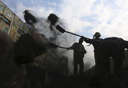 Labourers shovel coal onto a truck at a coal dump site outside Kabul in this January 23, 2014 file photo. REUTERS/Omar Sobhani/Files