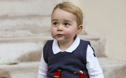 An official photo of Prince George of Cambridge sitting in a courtyard at Kensington Palace, wearing a Cath Kidston jumper - Credit: - Source: AFP