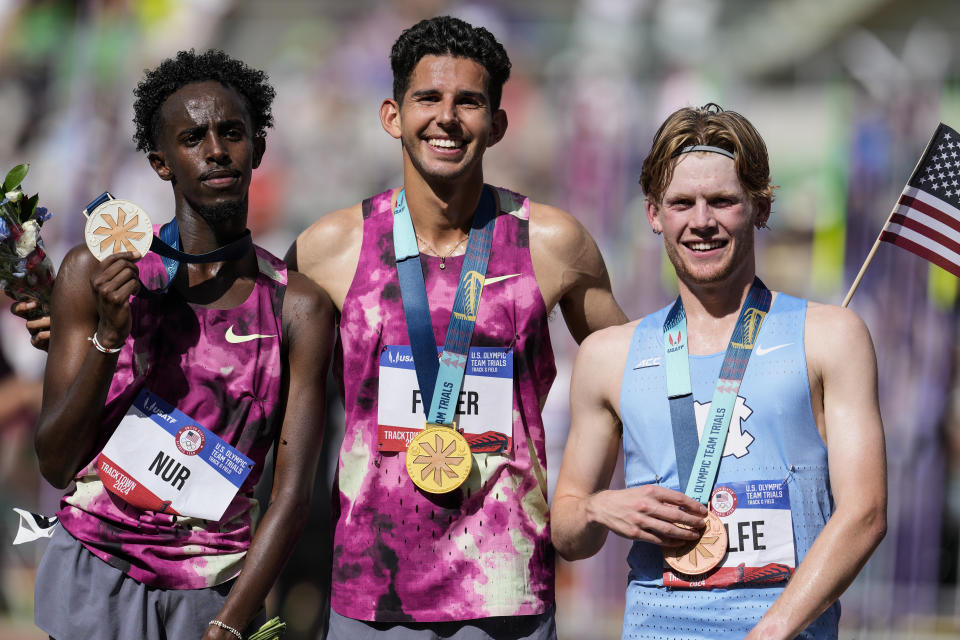 First place winner Grant Fisher, center, and second place winner Abdihamid Nur, left, and third place finisher Parker Wolfe pose for a photo after the wins the men's 5000-meter final run during the U.S. Track and Field Olympic Team Trials, Sunday, June 30, 2024, in Eugene, Ore. (AP Photo/George Walker IV)