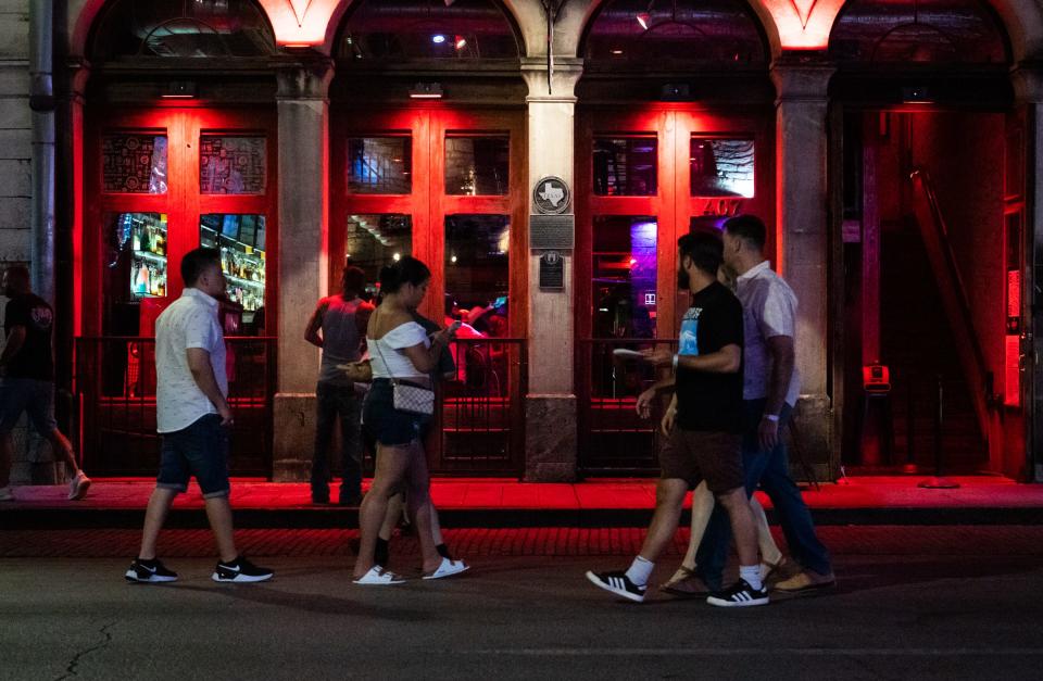 Pedestrians walk past bars and entertainment venues on Sixth Street in Austin last week. Live music venues are currently treated as cocktail lounges in city code, which heavily restricts the areas in which they're allowed to operate, a city consultant said.