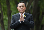 Thailand's Prime Minister Prayuth Chan-ocha gives the traditional greeting, or "wai," as he talks to reporters before meeting at government house in Bangkok, Thailand, Thursday, June 6, 2019. Thailand's Parliament elected 2014 coup leader Prayuth Chan-ocha as prime minister in a vote Wednesday that helps ensure the military's sustained dominance of politics since the country became a constitutional monarchy nearly nine decades ago. (AP Photo/Sakchai Lalit)