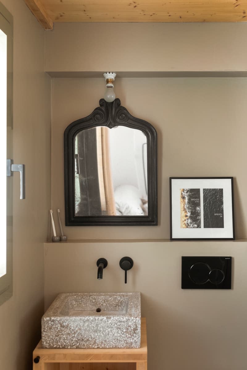 gray bathroom with black framed mirror and other black details