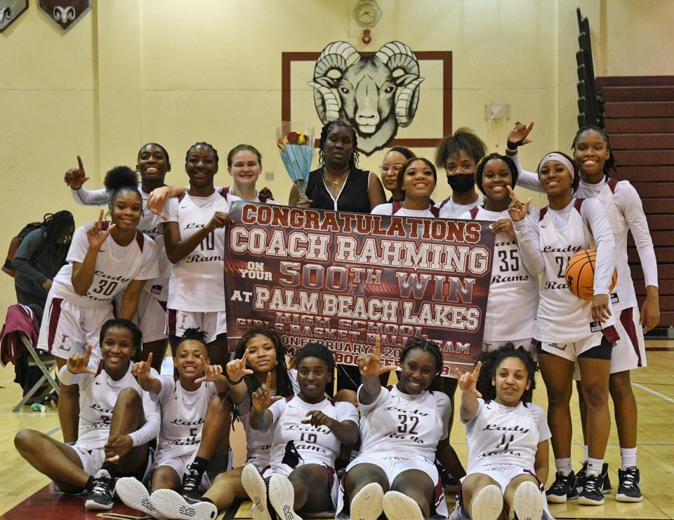 Palm Beach Lakes head coach Cassandra Rahming (center) and the Rams players pose for a group photo with the new school banner celebrating the veteran coach's 500th career victory on Feb. 1, 2022.