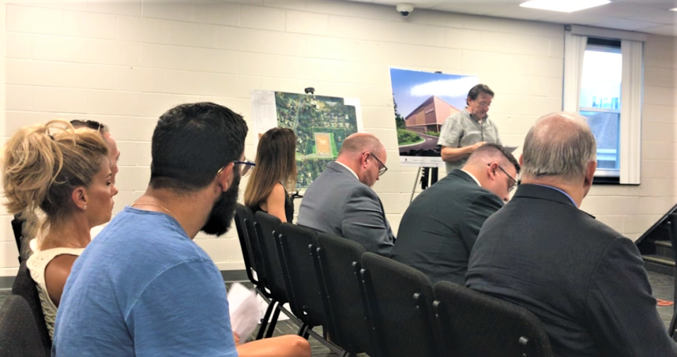 The Glassboro Zoning Board on Thursday night heard testimony for and against a proposed self-storage facility at 214 East High Street. Boro Commons Homeowners Association Vcie President Joseph Reilly stands in front of project exhibits to list the group's objections. The board approved the project on a 5-2 vote. Representatives of the developer watch from the front row. PHOTO: July 20, 2023.