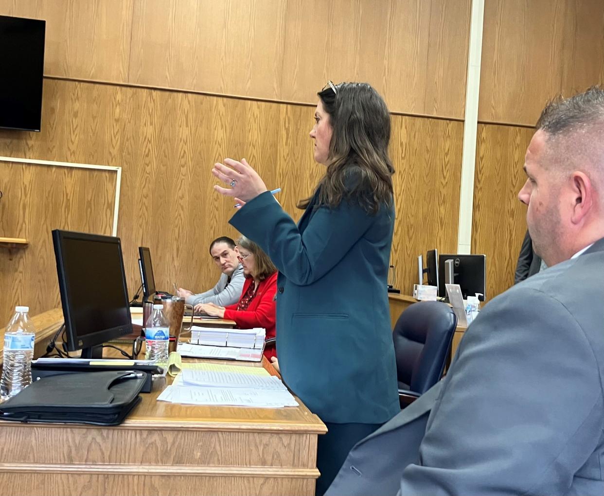 Assistant Licking County Prosecutor Darcy Cook stands to speak to county Common Pleas Judge David Branstool while defendant David Perrine (next to wall) and his attorney, Kristen Burkett, listen during the opening day of testimony in the murder trial of Perrine, charged in the killing of his mother, Debra Perrine.