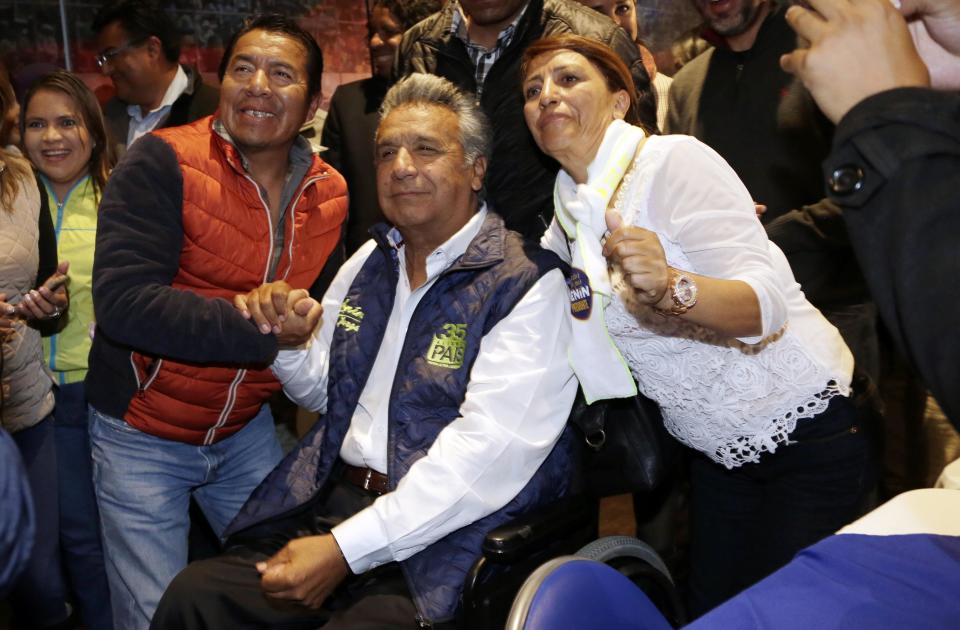 Lenin Moreno, presidential candidate for the ruling party Alliance PAIS, center, poses for a photo with supporters after a news conference in Quito, Ecuador, Monday, Feb. 20, 2017. The hand-picked candidate of President Rafael Correa, Moreno held an easy lead Monday in Ecuador's presidential election, though authorities said it might be a few more days before they determine if Moreno won enough votes to avoid a runoff against his nearest rival. (AP Photo/Dolores Ochoa)