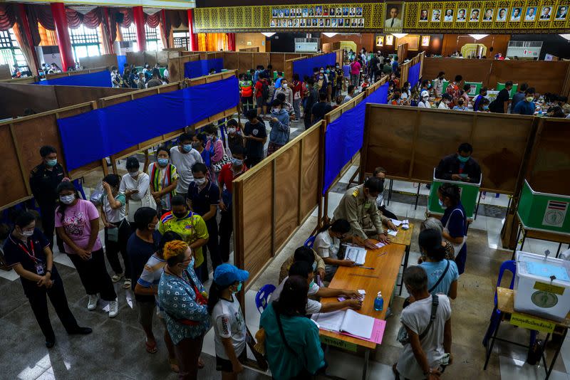 People line up for their early vote for Thailand's upcoming general election at a polling station in Bangkok