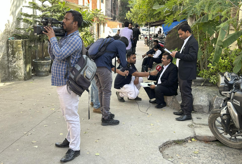 Journalists speak to lawyers outside the office of Delhi Police's Special Cell in New Delhi, India, Tuesday, Oct. 3, 2023. Indian police raided the offices of a news website that's under investigation for receiving funds from China, as well as the homes of several of its journalists, in what critics described as an attack on one of India's few remaining independent news outlets. The raids came months after Indian authorities searched the BBC's New Delhi and Mumbai offices over accusations of tax evasion in February. (AP Photo/Piyush Nagpal)