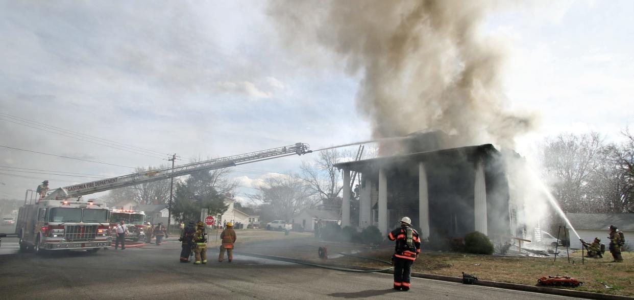 Firefighters work to battle a house fire Tuesday afternoon, Feb. 21, 2023, on West Virginia Avenue in Bessemer City.