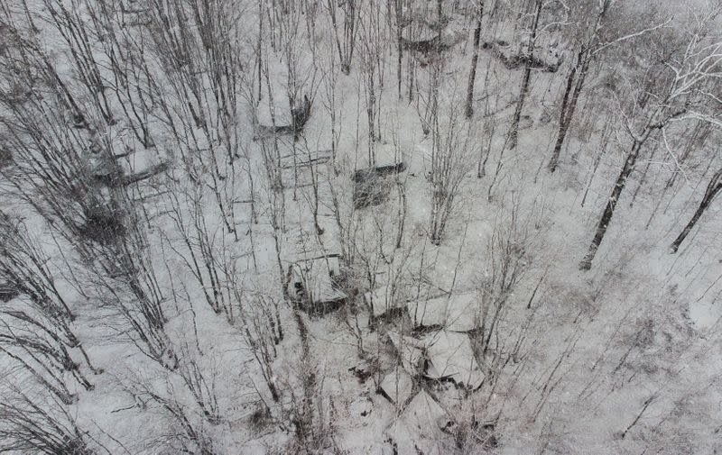 Tents in makeshift camp are seen during snowfall in a forest near Velika Kladusa