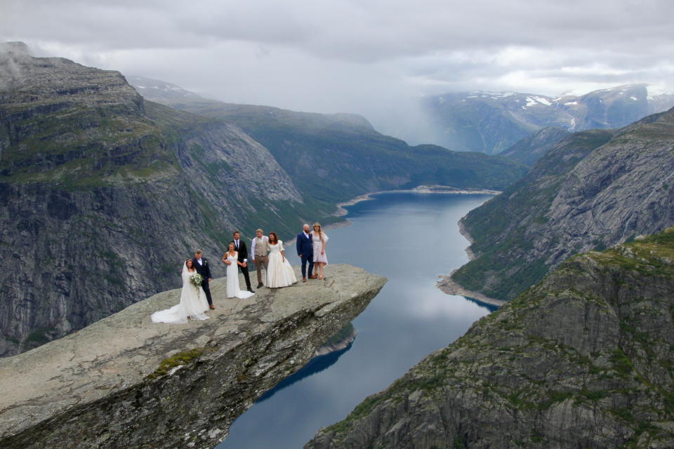 Bridal couples Lise Sydnes Bordal and Njal-Stian Bordal, Ina Kulsveen and Kjetil Skjaerbaek, Katarina Karlsson and Fredrik Gustavsson, and Tinna Bundgaard Frentz and Kasper Sorensen, who were married by mayor of Ullensvang Roald Aga Haug, take part in the first wedding ceremony at Trolltunga, Norway August 14, 2021. Ase Marie Evjen/Trolltunga AS/NTB/via REUTERS   ATTENTION EDITORS - THIS IMAGE WAS PROVIDED BY A THIRD PARTY. NORWAY OUT. NO COMMERCIAL OR EDITORIAL SALES IN NORWAY.