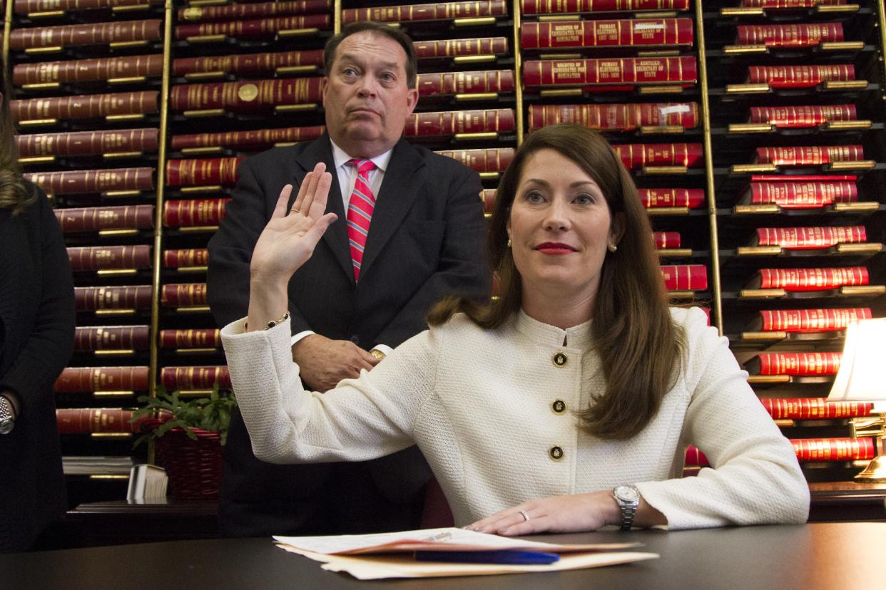 With her father, Jerry Lundergan, standing by, Kentucky Secretary of State Alison Lundergan Grimes takes her oath of office in Frankfort in 2015.