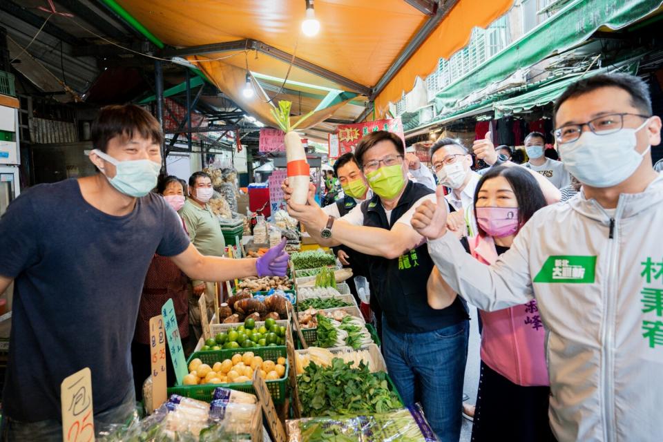 林佳龍到新莊宏泰市場掃街拜票，攤商送蘿蔔祝福。   圖：林佳龍競辦提供