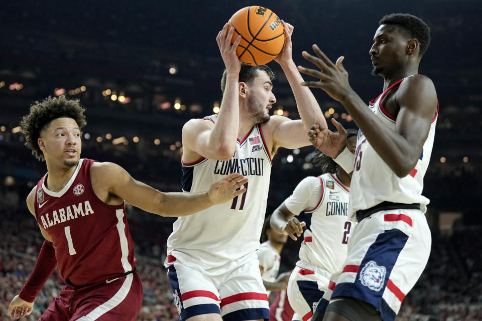 UConn forward Alex Karaban (11) pulls down a rebound as Alabama guard Mark Sears (1) defends during the second half of the NCAA college basketball game at the Final Four, Saturday, April 6, 2024, in Glendale, Ariz. (AP Photo/Brynn Anderson )