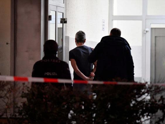 Police handcuff a man near the scene of a shooting in Hanau (Boris Roessler/DPA via AP)