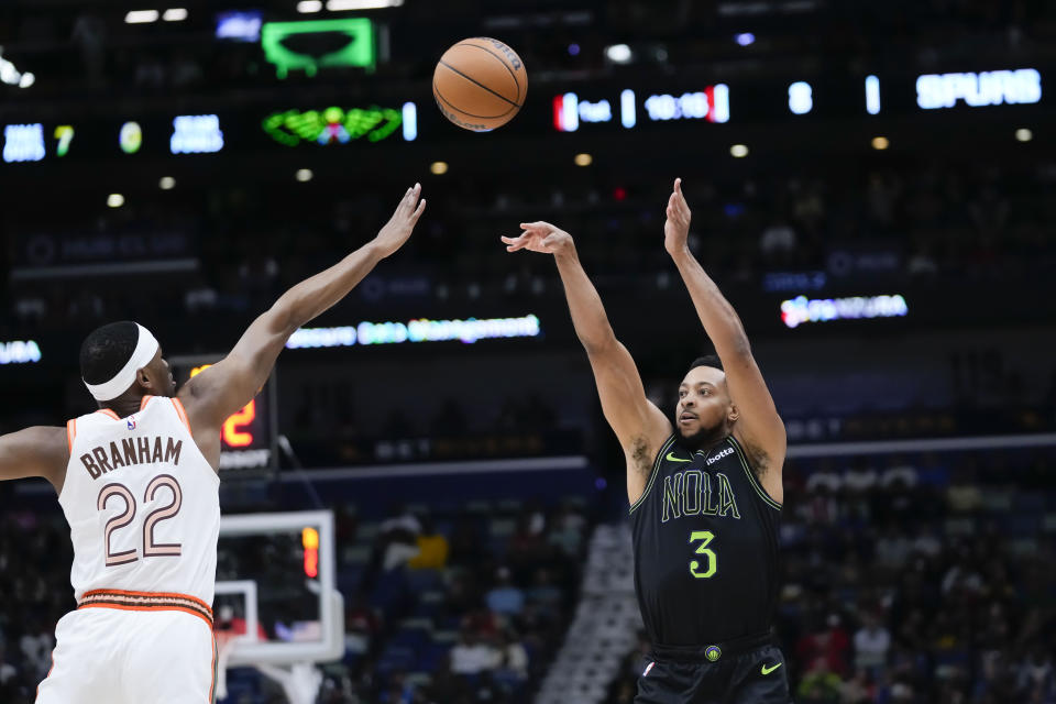 New Orleans Pelicans guard CJ McCollum (3) shoots against San Antonio Spurs guard Malaki Branham (22) in the first half of an NBA basketball game in New Orleans, Friday, Dec. 1, 2023. (AP Photo/Gerald Herbert)