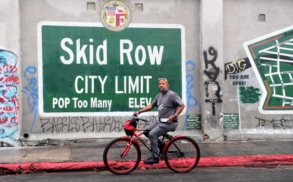 A cyclist rides past a Skid Row sign in Los Angeles on Feb. 1. A group of downtown businesses and residents sued local government officials over their handling of the area&rsquo;s expanding homelessness crisis. (Photo: FREDERIC J. BROWN via Getty Images)