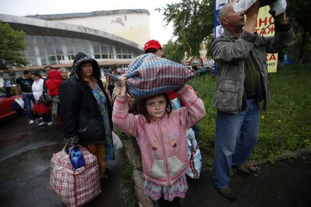 Residents of the Donetsk region in eastern Ukraine prepare to board buses for Rostov-on-Don in Russia from a collection point in Donetsk July 14, 2014. REUTERS/Maxim Zmeyev