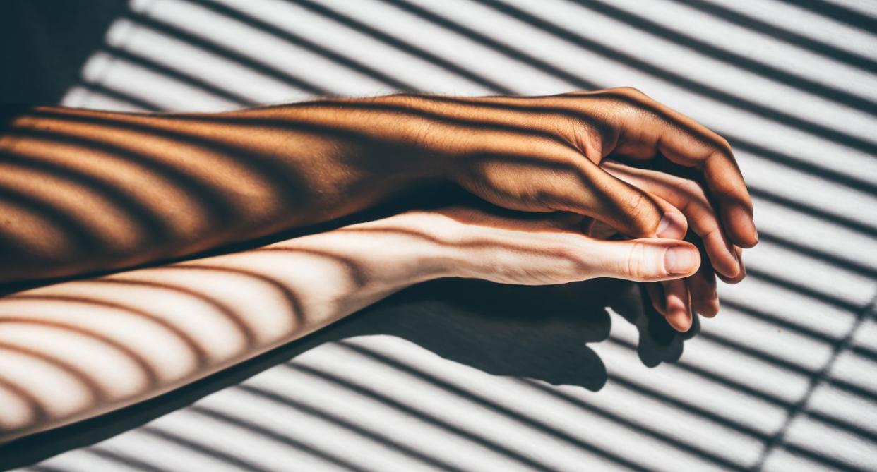 Two hand holding in bed, to represent sex with endometriosis. (Getty Images)