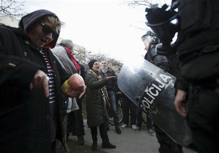 A protester speaks to a police officer in front of a government building in Sarajevo February 8, 2014. REUTERS/Antonio Bronic