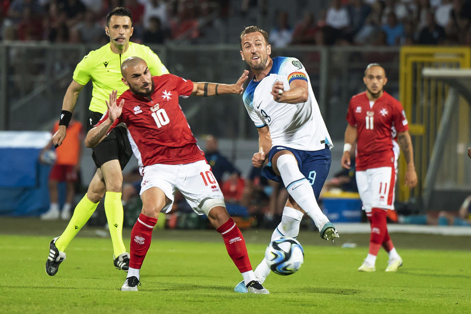 England's Harry Kane, right, challenges for the ball with Malta's Teddy Teuma during the Euro 2024 group C qualifying soccer match between Malta and England at the National stadium in Ta' Qali, near Valletta, Malta, Friday, June 16, 2023. (AP Photo/Rene Rossignaud)