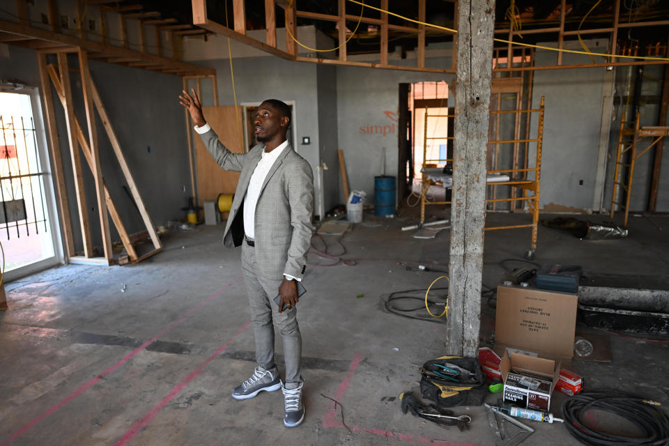 Tahir Johnson stands in a room under construction.