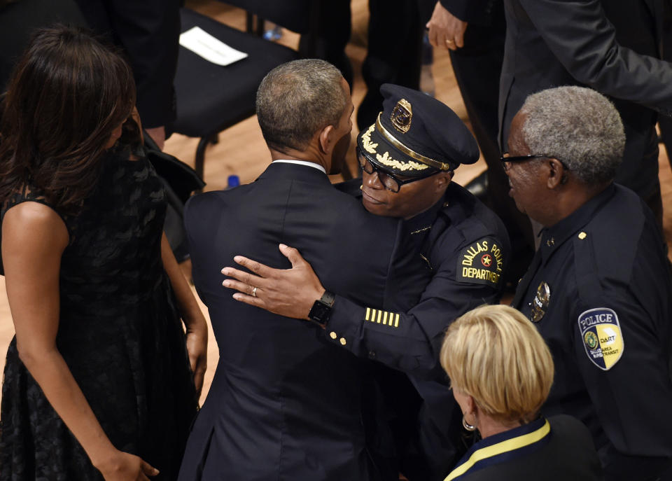 FILE - In this Tuesday, July 12, 2016 file photo, President Barack Obama hugs Dallas Police Chief David Brown at the end of an interfaith memorial service for the fallen police officers and members of the Dallas community at the Morton H. Meyerson Symphony Center in Dallas. With racial tensions rising, Obama praised law enforcement officials for their courage while also expressing the need to understand the grievances of African-Americans who've protested racial bias. "I'm here to say we must reject such despair," the president says. "I'm here to insist that we are not as divided as we seem. And I know that because I know America. I know how far we've come against impossible odds." (AP Photo/Susan Walsh)