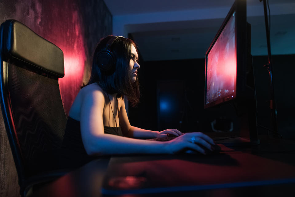 A female gamer streams gameplay on her PC.