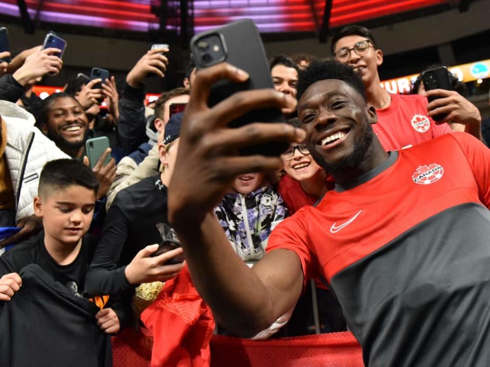 Canadian star Alphonso Davies takes a photo with fans after a match in Vancouver on June 9. Davies, who plays for German club Bayern Munich, is regarded as one of the world's top young players. (Don MacKinnon/AFP/Getty Images - image credit)