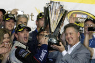 FILE - In this Nov. 22, 2009, file photo, Jimmie Johnson, left, raises the trophy with NASCAR chairman Brian France, right, after winning the NASCAR Sprint Cup Series season championship at Homestead-Miami Speedway in Homestead, Fla. Jimmie Johnson is the latest NASCAR superstar to climb out of his car, with the seven-time champion announcing Wednesday, Nov. 20, 2019, that 2020 will be his final season of full-time racing. (AP Photo/Chuck Burton, File)
