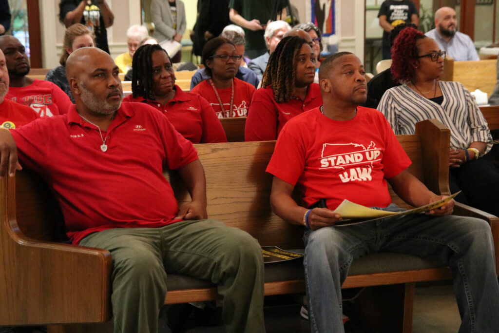 Men in red shirts listening