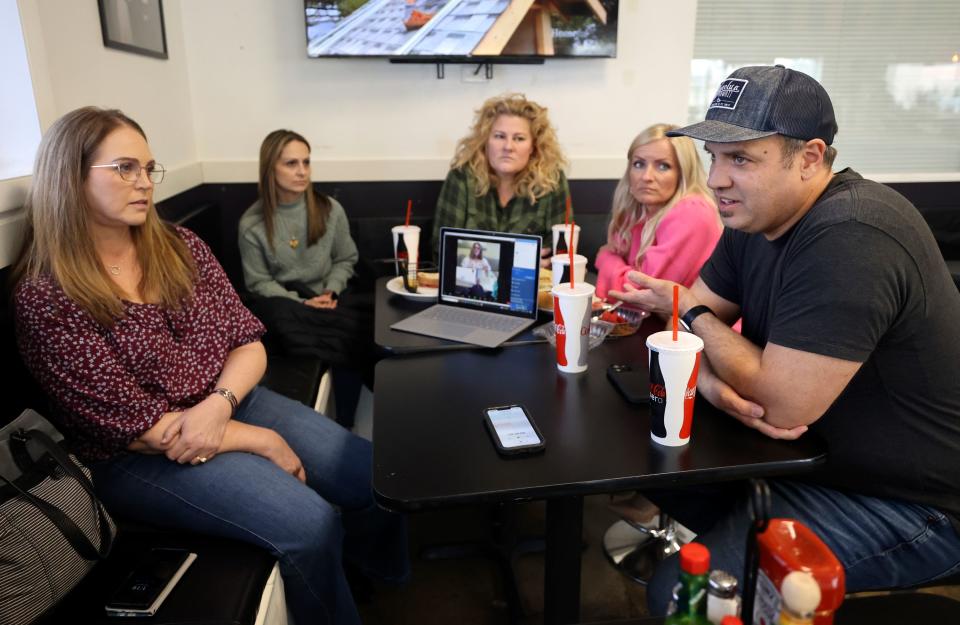 Jennifer May, Catrina Nelson, Emilie Campbell, April Sintz and Clint Atwater surround a computer to include Annette Maughan on a video call as they answer interview questions about fighting to legalize CBD oil in Utah, to try and alleviate their children’s seizures, at Avenue Bakery in American Fork on Monday, March 20, 2023. | Kristin Murphy, Deseret News