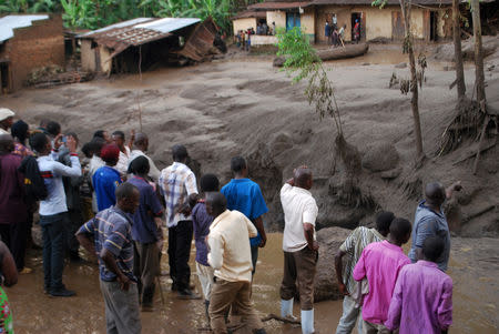 Survivors look at the aftermath as flood waters pass through destroyed homes, after a landslide rolled down the slopes of Mt. Elgon through their village in Bududa district, Uganda October 12, 2018. REUTERS/Stringer