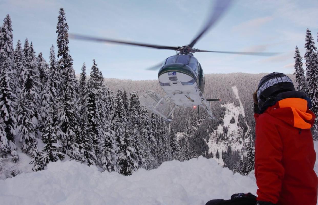 A undated photo taken from Northern Escape Heli-Skiing's Facebook page shows a helicopter landing in the B.C. mountains. The company confirmed that three people were killed in a helicopter crash during one of its excursions on Monday. (Northern Escape Heli-Skiing - image credit)