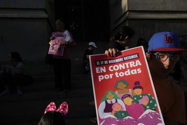 Un chico muestra un poster contra el proyecto constitucional, en Santiago de Chile
