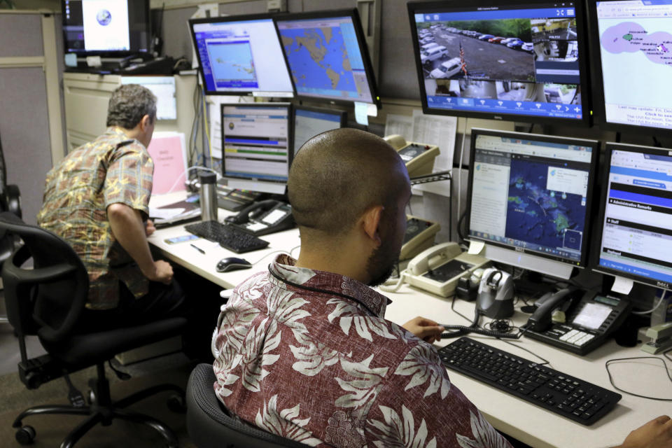 FILE - Hawaii Emergency Management Agency officials work at the department's command center in Honolulu on Dec. 1, 2017. A Cold War-era law in Hawaii that allows authorities to impose sweeping restrictions on press freedoms and electronic communications during a state of emergency could soon be repealed by lawmakers after concerns about its constitutionality and potential misuse in an era of increasing polarization. (AP Photo/Caleb Jones, File)