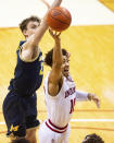 Indiana guard Rob Phinisee (10) drives to the basket with the ball as Michigan guard Franz Wagner (21) attempts to block his shot during the second half of an NCAA college basketball game, Saturday, Feb. 27, 2021, in Bloomington, Ind. (AP Photo/Doug McSchooler)