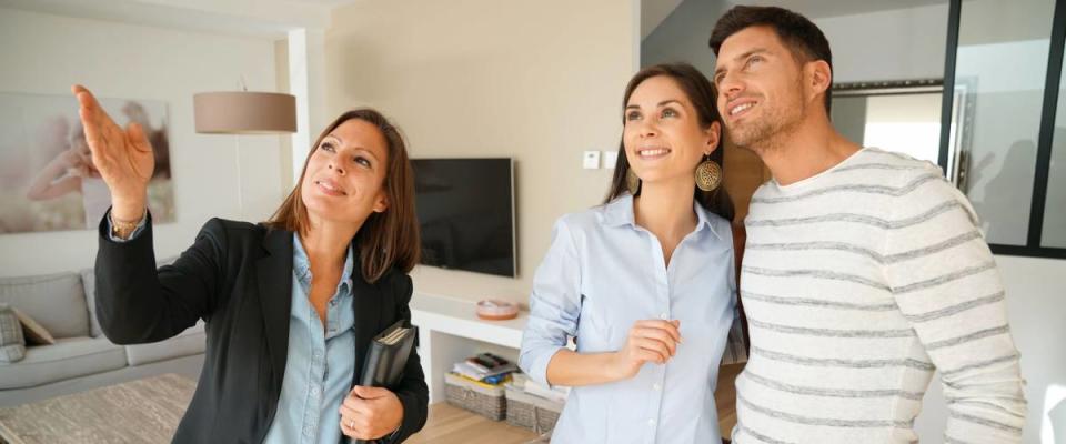 Couple with real-estate agent visiting house for sale