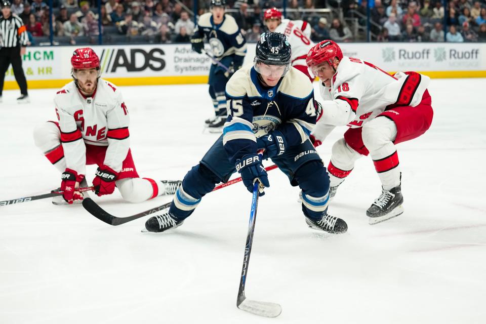 Apr 16, 2024; Columbus, Ohio, USA; Columbus Blue Jackets center Gavin Brindley (45) spins around Carolina Hurricanes center Jack Drury (18) during the third period of the NHL hockey game at Nationwide Arena.