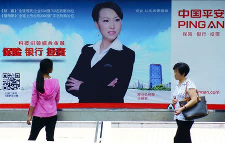 People walk past an advertisement of Ping An, in Yichang, Hubei province, China, August 19, 2015. REUTERS/Stringer