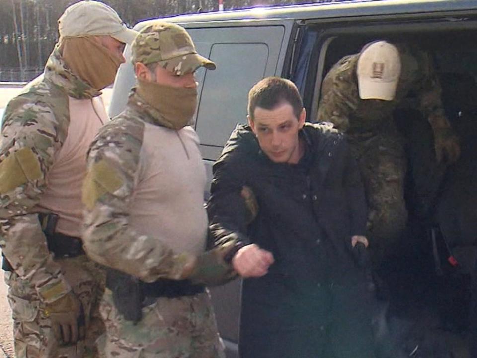 Trevor Reed, 30, being escorted by Russian service members (via REUTERS)