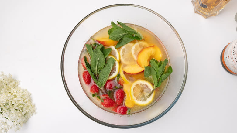 assembling summer punch in bowl