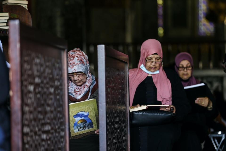 Three women recite the Quran at Al-Aqsa Mosque  in Jerusalem.