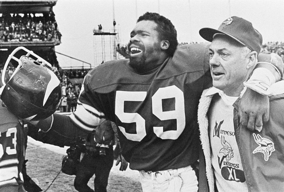 Minnesota Vikings coach Bud Grant breaks into a rare on-field smile as he heads toward the dressing room with linebacker Matt Blair after a last-second 28-23 victory over the Cleveland Browns in Bloomington, Minn., Dec. 14, 1980.