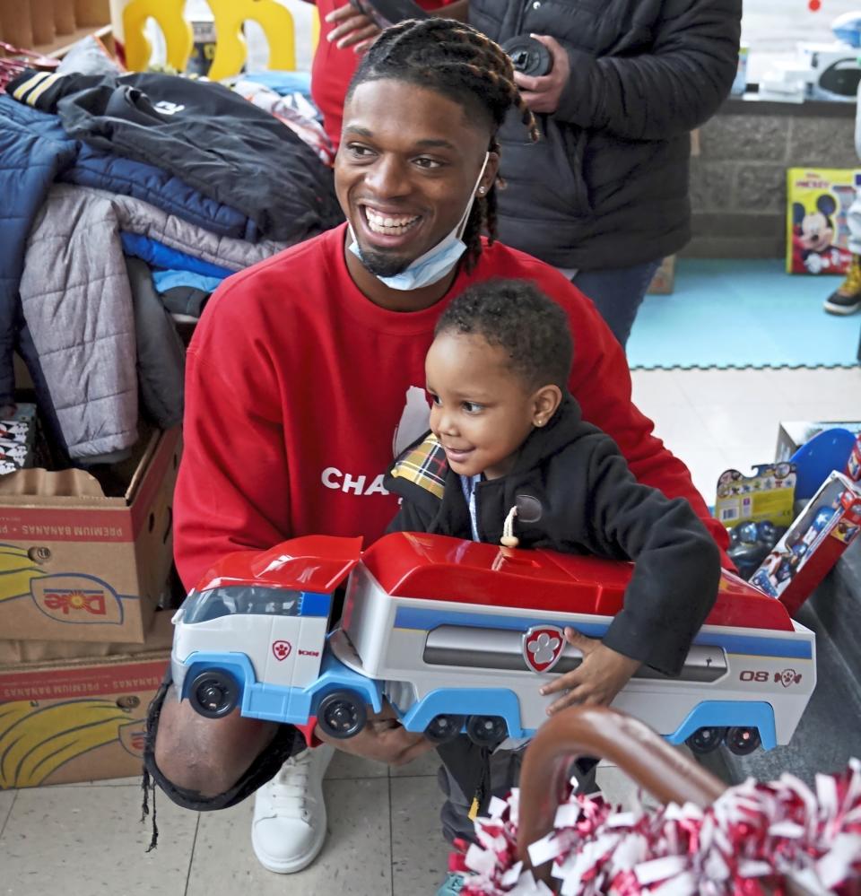 FILE - Pittsburgh NCAA college football defensive back Damar Hamlin poses for a photo with Bryce Williams, 3, of McKees Rocks, Pa., after the youngster picked out a toy during Hamlin's Chasing M's Foundation community toy drive at Kelly and Nina's Daycare Center, Tuesday, Dec. 22, 2020, in McKees Rocks, Pa. Buffalo Bills safety Damar Hamlin plans to support young people through education and sports with the $8.6 million in GoFundMe donations that unexpectedly poured into his toy drive fundraiser after he suffered a cardiac arrest in the middle of a game last week. (Matt Freed/Pittsburgh Post-Gazette via AP, File)